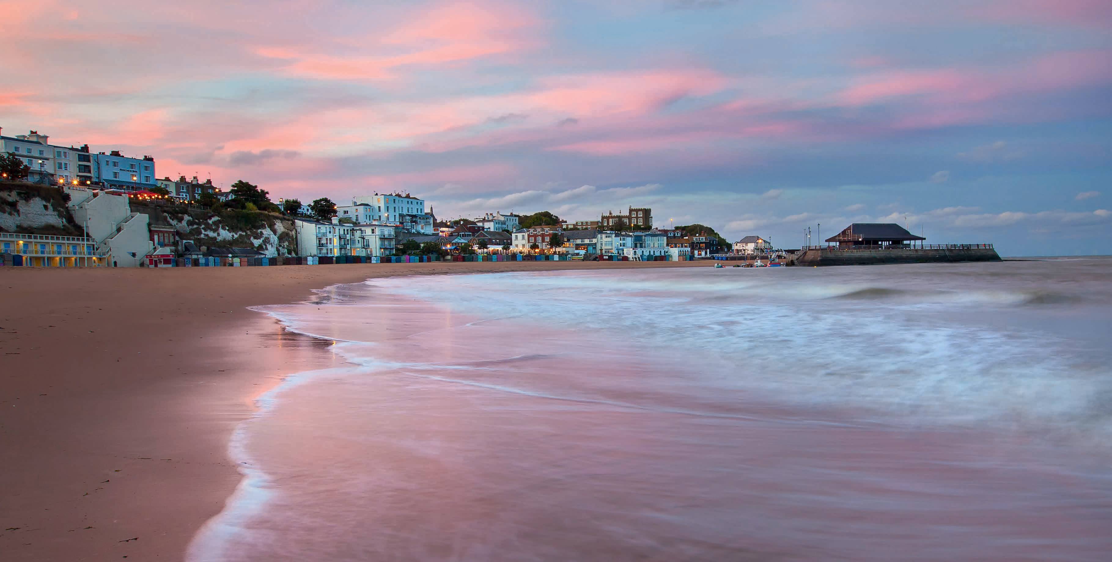 Sunset at Viking Bay, Broadstairs with pink and purple sky and waves across the beach